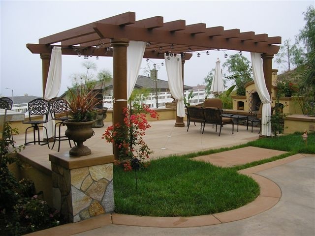This is an example of a mid-sized mediterranean backyard patio in San Diego with a water feature, concrete slab and a pergola.
