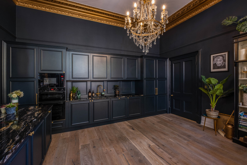 サセックスにある高級な広いトラディショナルスタイルのおしゃれなキッチン (ドロップインシンク、インセット扉のキャビネット、青いキャビネット、御影石カウンター、青いキッチンパネル、木材のキッチンパネル、黒い調理設備、淡色無垢フローリング、茶色い床、黒いキッチンカウンター、格子天井) の写真