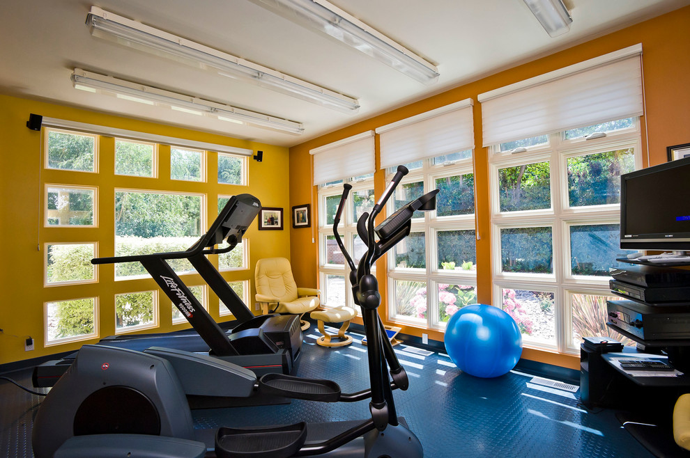 Photo of a contemporary home gym in San Francisco with orange walls and blue floor.