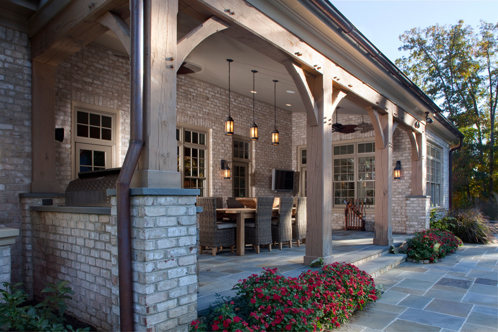 Inspiration for an expansive traditional backyard verandah in Richmond with natural stone pavers and a roof extension.