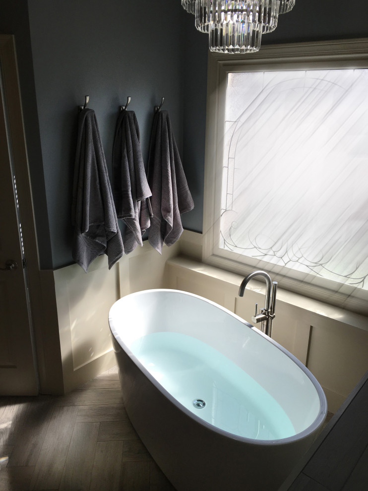 Large transitional master beige tile and ceramic tile porcelain tile and gray floor freestanding bathtub photo in Atlanta with recessed-panel cabinets, yellow cabinets, a two-piece toilet, blue walls, an undermount sink, granite countertops, a hinged shower door and multicolored countertops