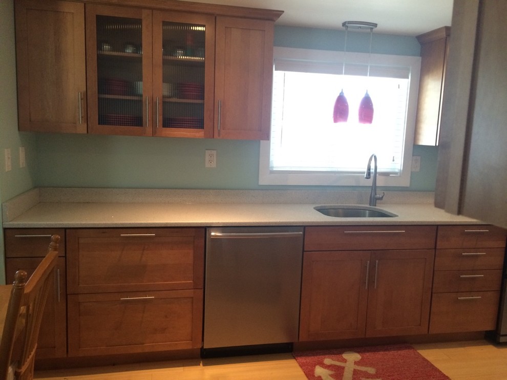 Eat-in kitchen - transitional galley light wood floor eat-in kitchen idea in Boston with an undermount sink, shaker cabinets, medium tone wood cabinets, quartz countertops, stainless steel appliances, no island and white countertops