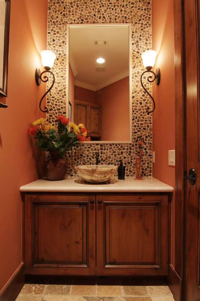 Mid-sized mediterranean powder room in Houston with raised-panel cabinets, dark wood cabinets, a one-piece toilet, beige tile, stone slab, orange walls, ceramic floors, a pedestal sink and soapstone benchtops.