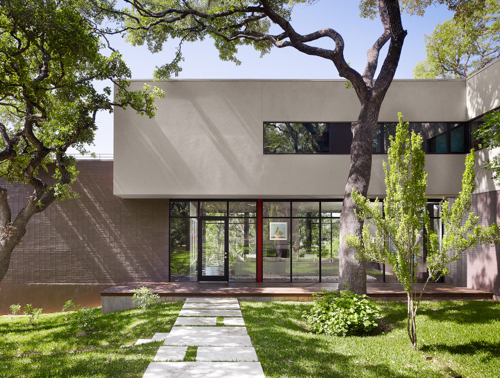 Photo of a contemporary two-storey brown exterior in Austin with stone veneer.