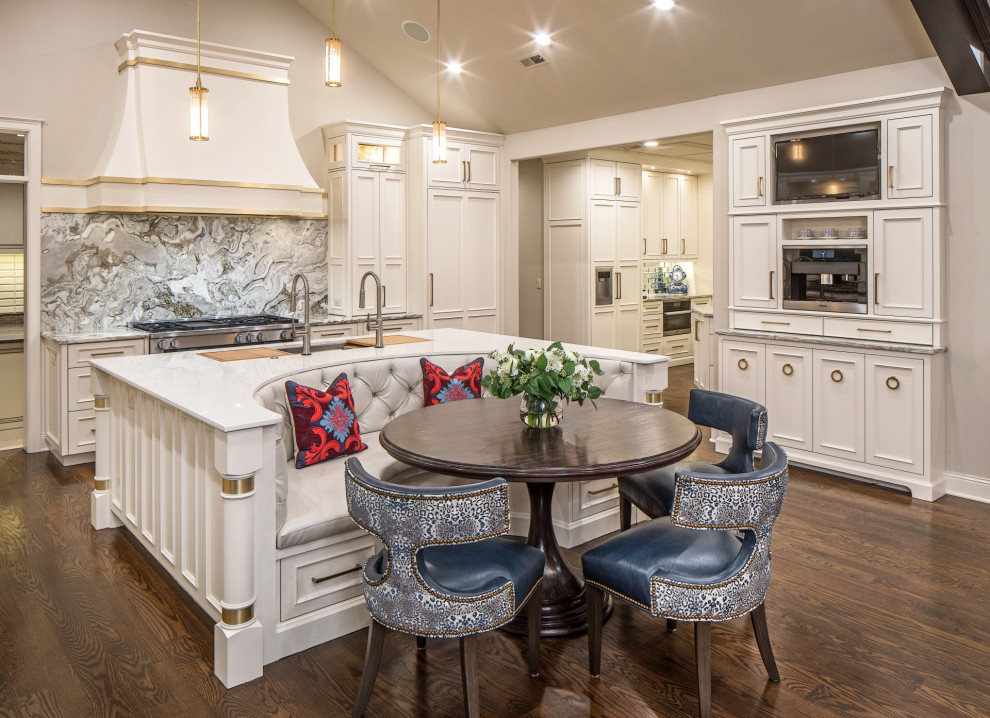 Photo of a large traditional u-shaped eat-in kitchen in Omaha with an undermount sink, recessed-panel cabinets, white cabinets, quartzite benchtops, grey splashback, marble splashback, panelled appliances, dark hardwood floors, with island, brown floor, white benchtop and vaulted.