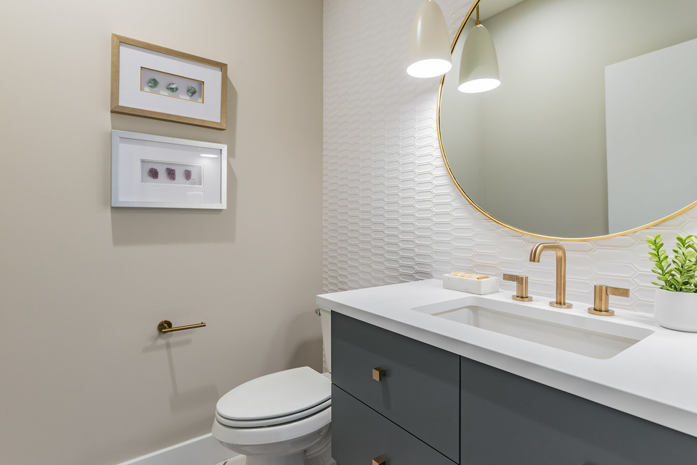 Inspiration for a small modern powder room in Austin with flat-panel cabinets, blue cabinets, a two-piece toilet, white tile, beige walls, an undermount sink, quartzite benchtops and white benchtops.