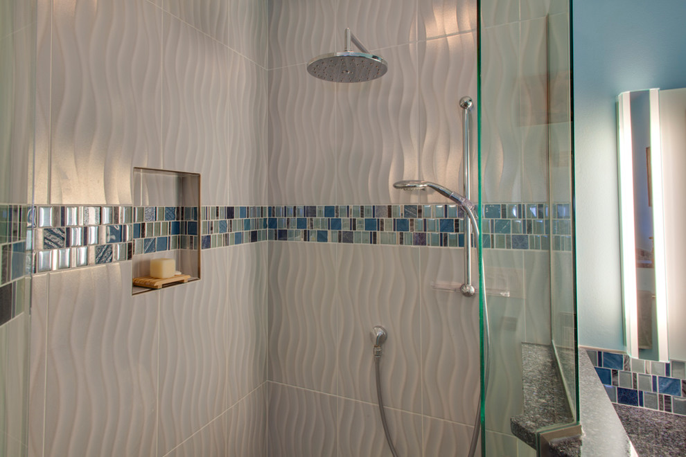 This is an example of a mid-sized tropical 3/4 bathroom in Tampa with flat-panel cabinets, white cabinets, a corner shower, multi-coloured tile, mosaic tile, blue walls, marble floors, an undermount sink, granite benchtops, grey floor, a hinged shower door, a japanese tub and a two-piece toilet.