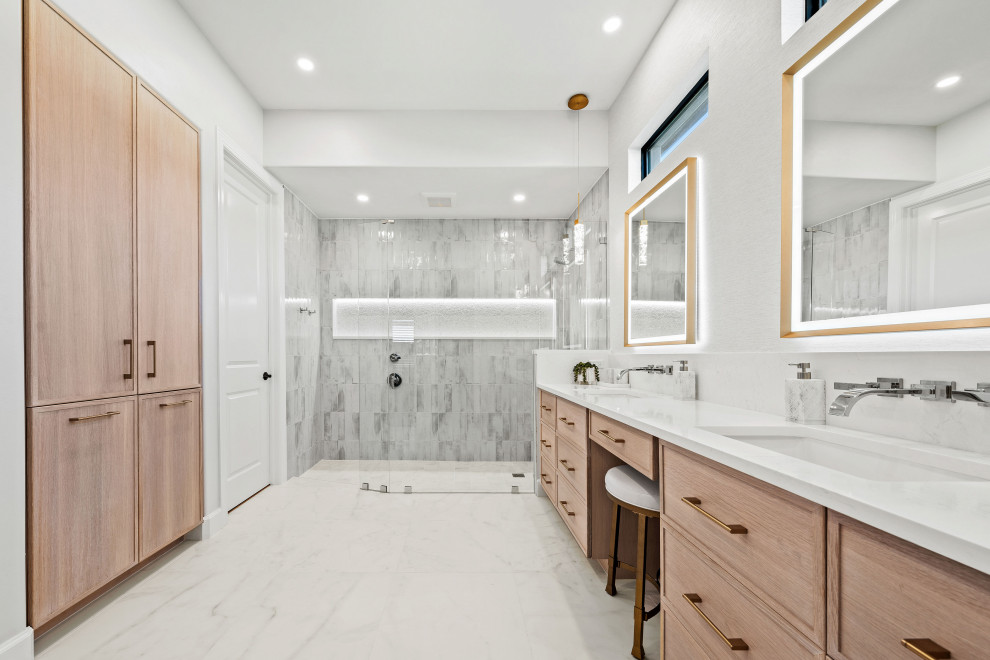 Transitional master gray tile and porcelain tile porcelain tile, white floor and double-sink walk-in shower photo with shaker cabinets, light wood cabinets, a two-piece toilet, white walls, an undermount sink, quartz countertops, white countertops, a niche and a built-in vanity
