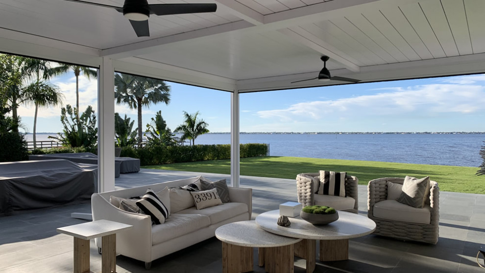 Photo of a mid-sized beach style backyard deck in Tampa with with privacy feature, a pergola and metal railing.
