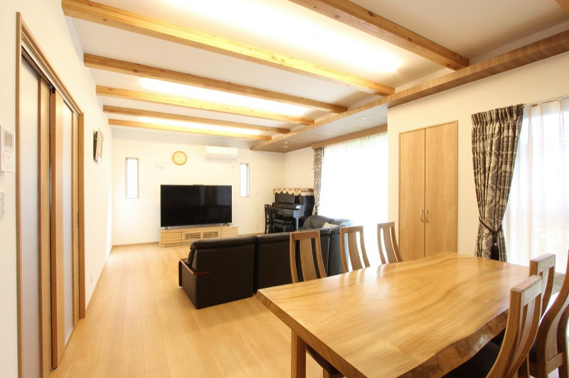 This is an example of a large open plan dining room in Fukuoka with white walls, plywood flooring, no fireplace, beige floors, exposed beams and wallpapered walls.