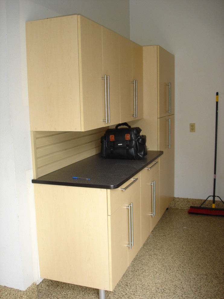 Large trendy attached three-car garage workshop photo