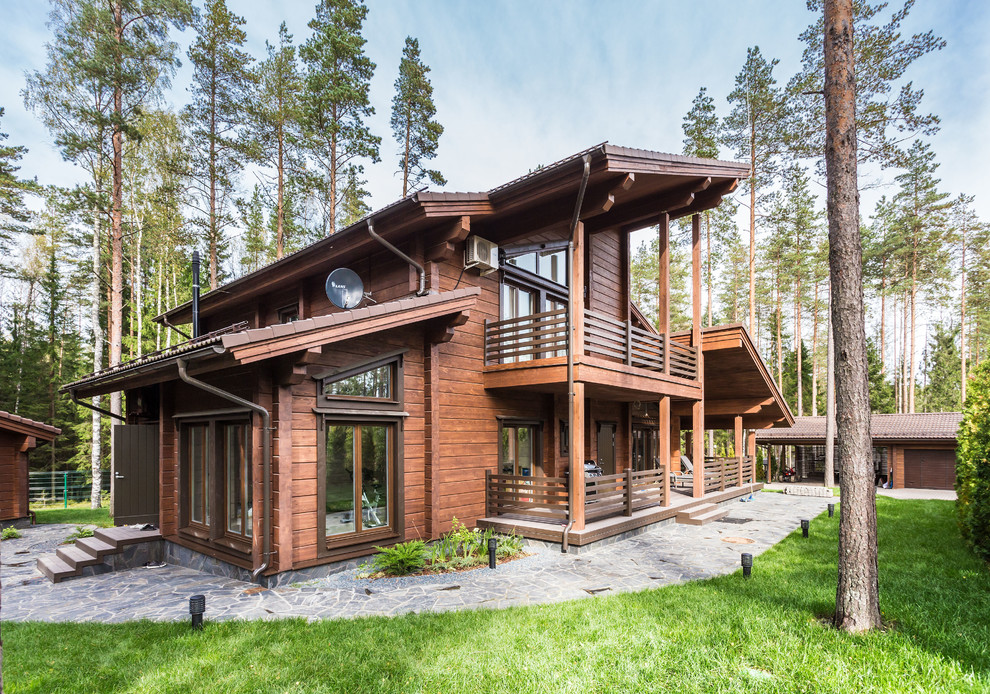 This is an example of a country two-storey brown exterior in Saint Petersburg with wood siding.
