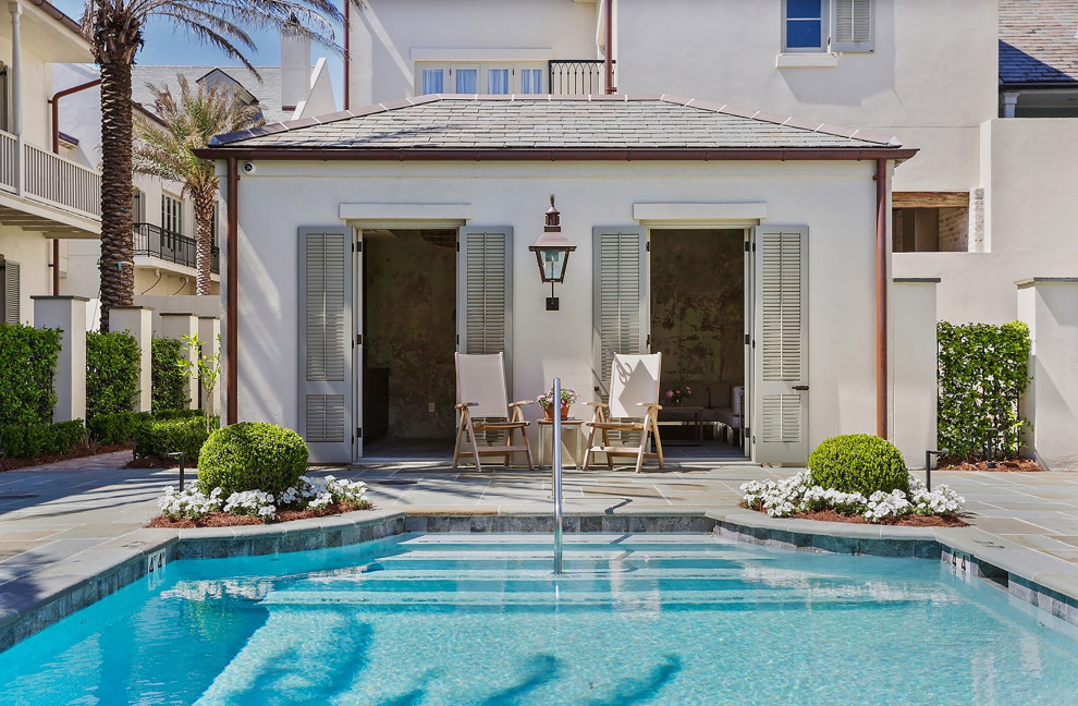 Imagen de piscina clásica de tamaño medio rectangular en patio con paisajismo de piscina y adoquines de piedra natural