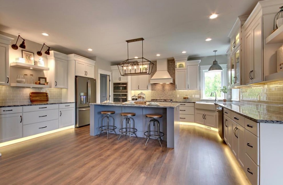 Large traditional eat-in kitchen in San Francisco with shaker cabinets, white cabinets, with island, vinyl floors and brown floor.