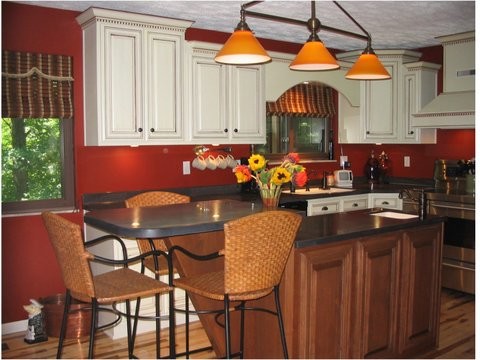 Example of a transitional u-shaped light wood floor kitchen design in Indianapolis with an undermount sink, raised-panel cabinets, white cabinets, stainless steel appliances, red walls and an island