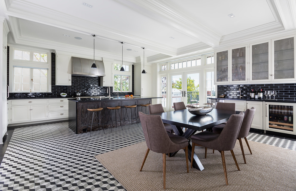 This is an example of an expansive transitional l-shaped open plan kitchen in San Francisco with white cabinets, soapstone benchtops, black splashback, subway tile splashback, panelled appliances, porcelain floors, with island and shaker cabinets.