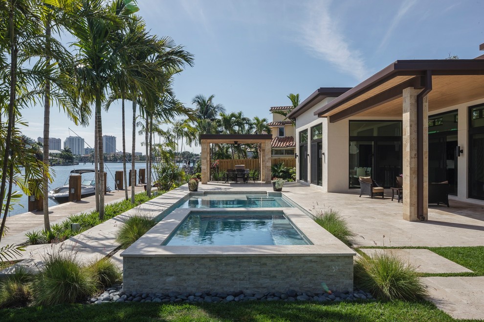 This is an example of a contemporary patio in Miami with a roof extension.