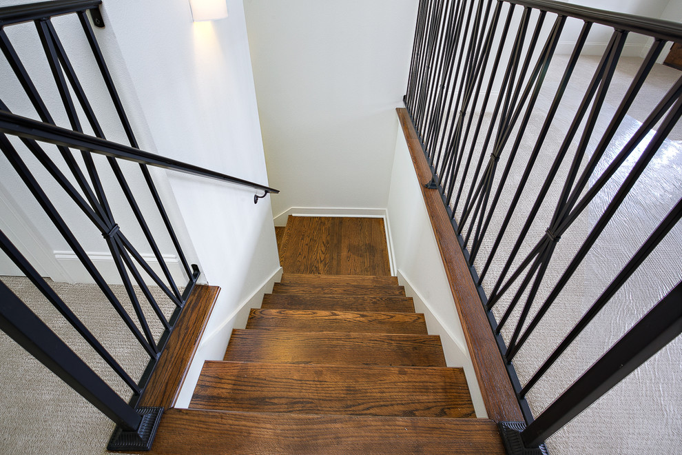 This is an example of a large classic wood l-shaped staircase in New Orleans with painted wood risers.