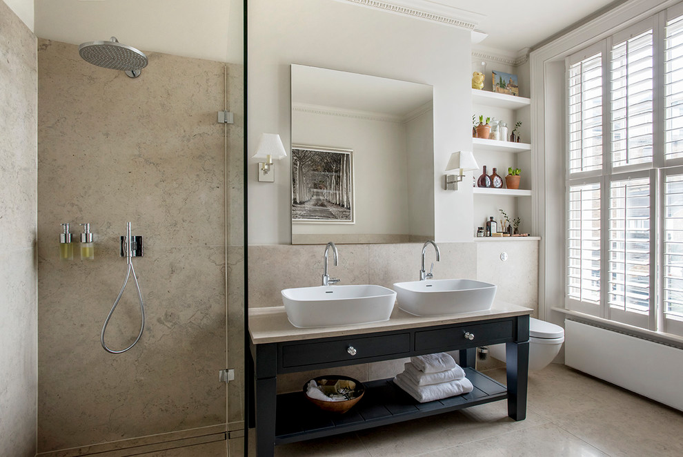Mid-sized transitional bathroom with flat-panel cabinets, blue cabinets, beige walls, a wall-mount toilet, a vessel sink, beige floor, an open shower, beige tile and beige benchtops.