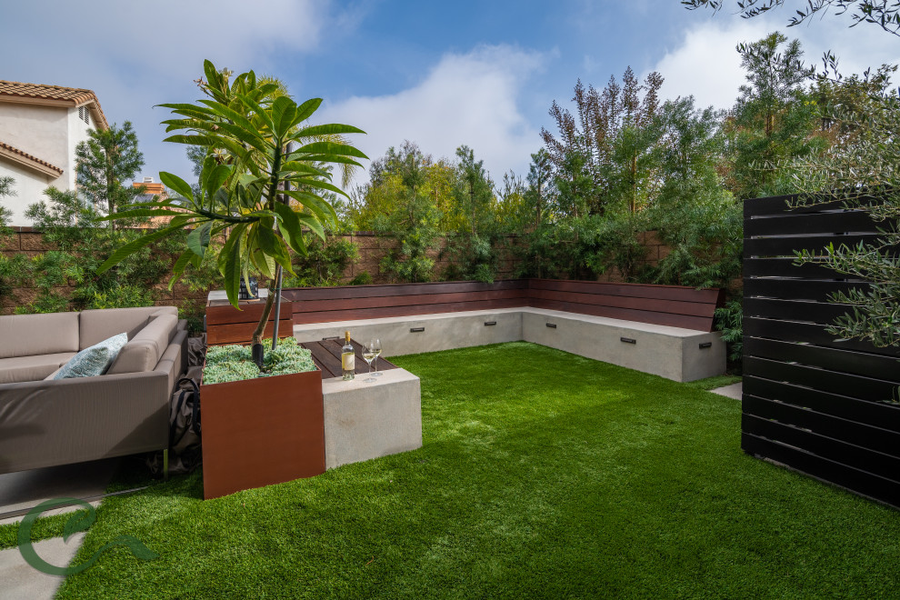 Small modern backyard patio in Los Angeles with a fire feature, concrete slab and a gazebo/cabana.