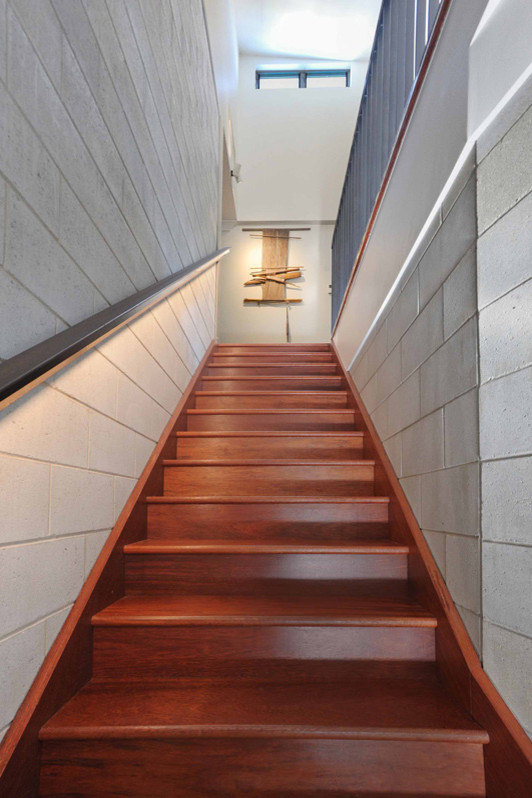 This is an example of a mid-sized modern wood straight staircase in Townsville with wood risers and metal railing.