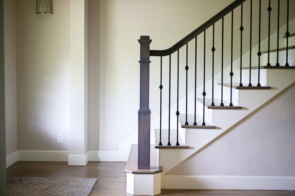 Photo of a mid-sized transitional wood straight staircase in Other with painted wood risers and metal railing.