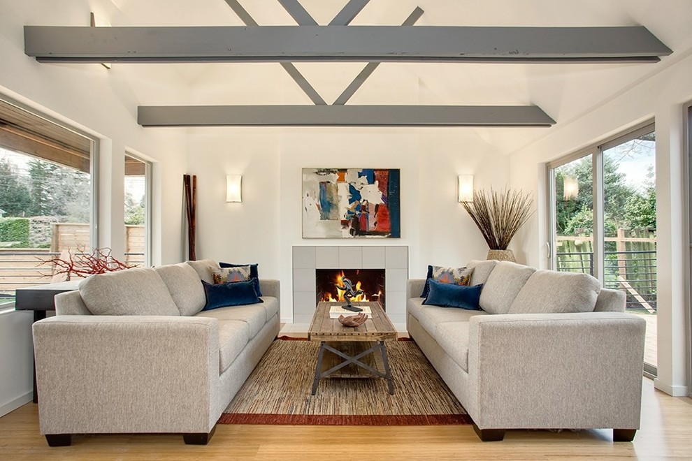 Photo of a transitional formal enclosed living room in Seattle with white walls, light hardwood floors, a standard fireplace, a tile fireplace surround and no tv.