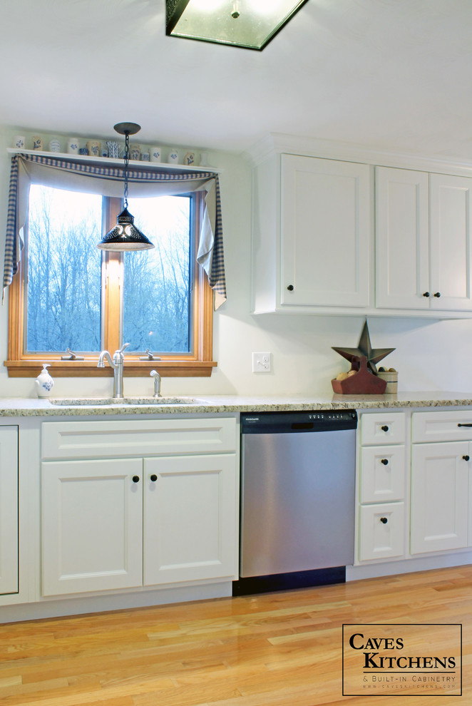 Example of a small transitional u-shaped medium tone wood floor eat-in kitchen design in New York with an undermount sink, recessed-panel cabinets, white cabinets, granite countertops, white backsplash, stainless steel appliances and no island