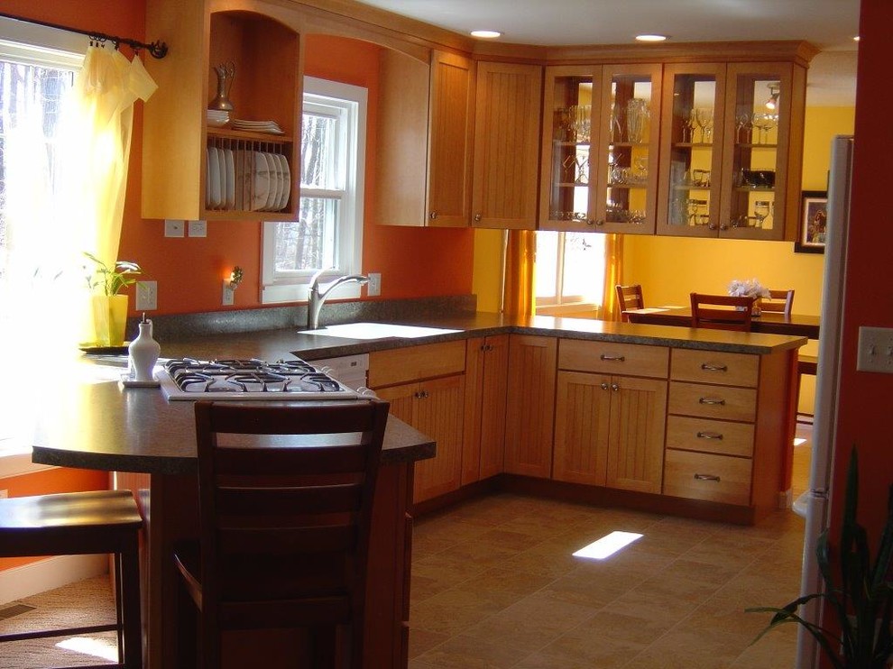 This is an example of a mid-sized traditional eat-in kitchen in Burlington with a single-bowl sink, glass-front cabinets, medium wood cabinets, white appliances and a peninsula.