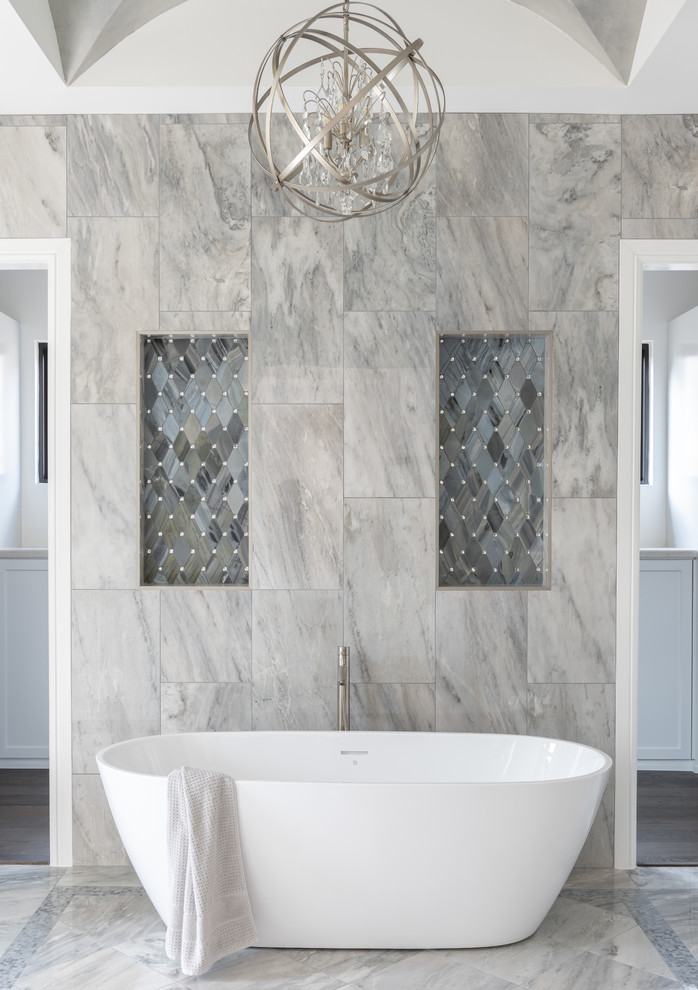 Inspiration for a large transitional master bathroom in Other with shaker cabinets, grey cabinets, a freestanding tub, a double shower, gray tile, marble, white walls, porcelain floors, an undermount sink, quartzite benchtops, grey floor, a sliding shower screen and grey benchtops.