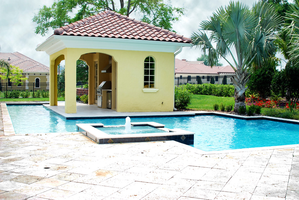 Photo of a large contemporary backyard custom-shaped lap pool in Orlando with a pool house and stamped concrete.