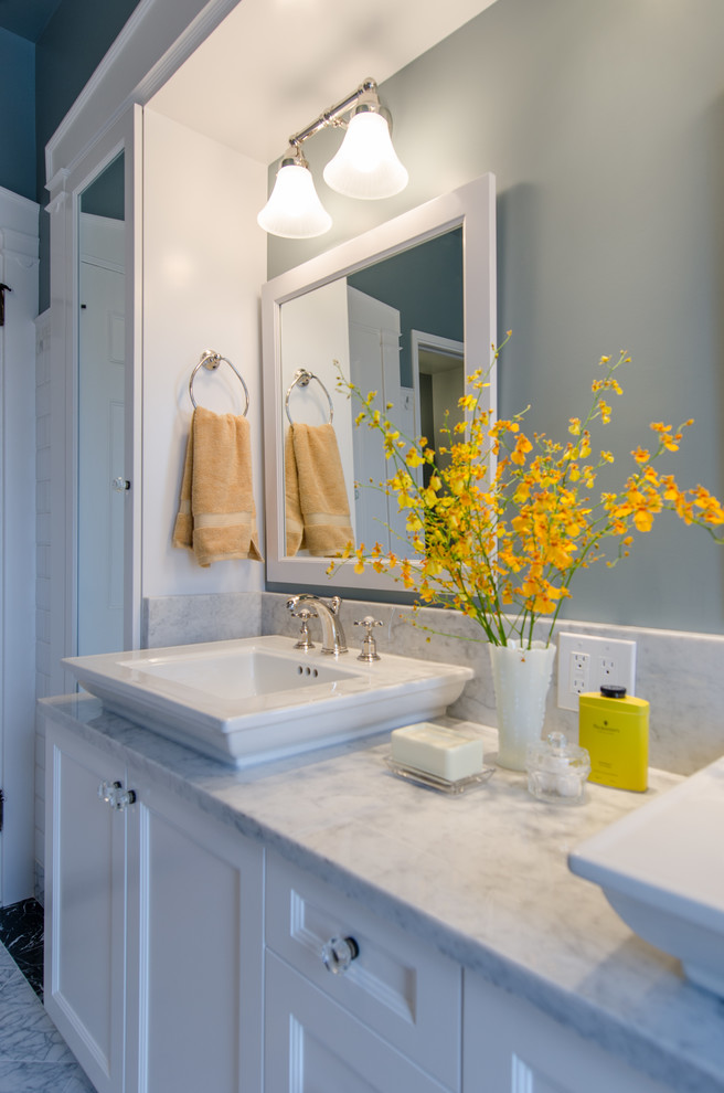 Inspiration for a mid-sized traditional master bathroom in Seattle with shaker cabinets, white cabinets, a freestanding tub, a corner shower, blue walls, marble floors, marble benchtops, white tile, ceramic tile, a vessel sink, multi-coloured floor, a hinged shower door and multi-coloured benchtops.