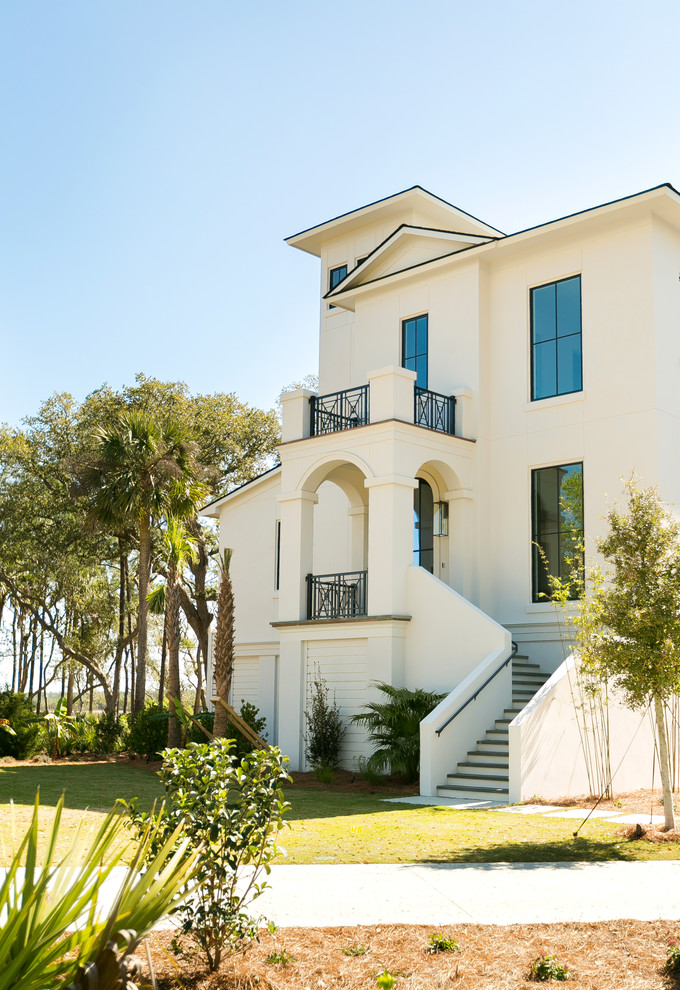 Photo of a transitional three-storey stucco white townhouse exterior in Charleston with a hip roof and a shingle roof.