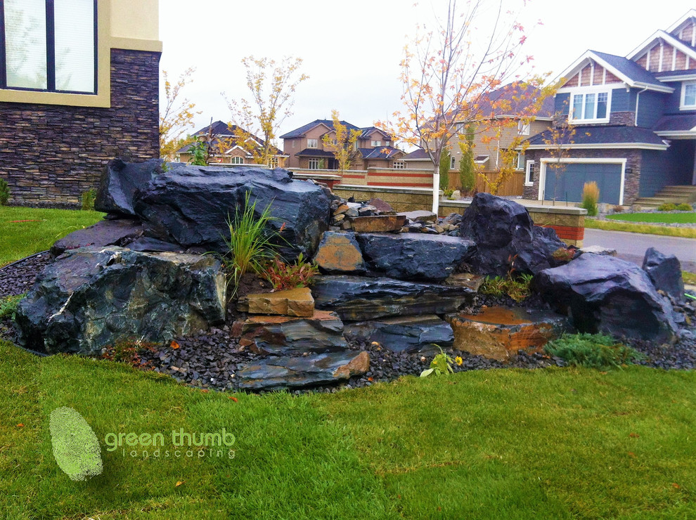 Design ideas for a rustic full sun front yard stone water fountain landscape in Edmonton for summer.