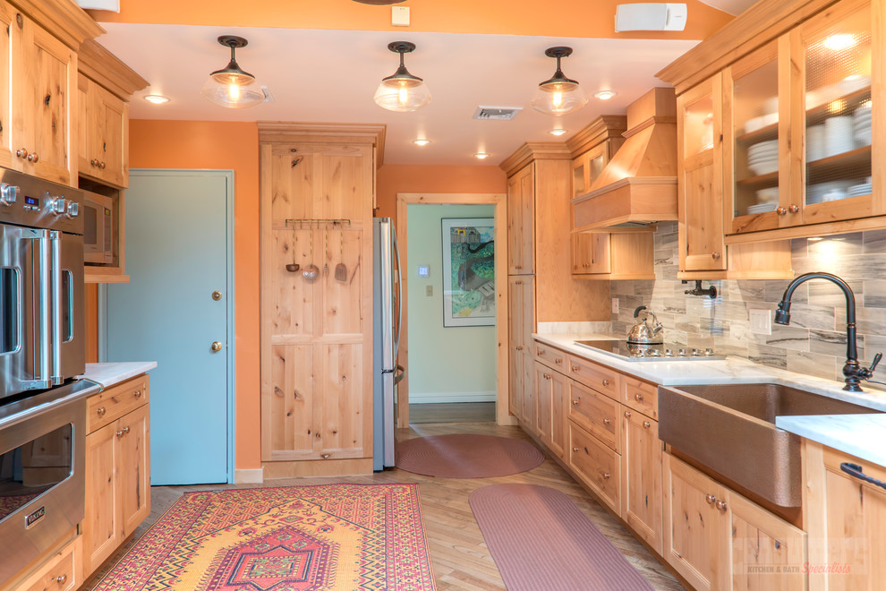 Example of an eat-in kitchen design in New York with marble countertops and no island