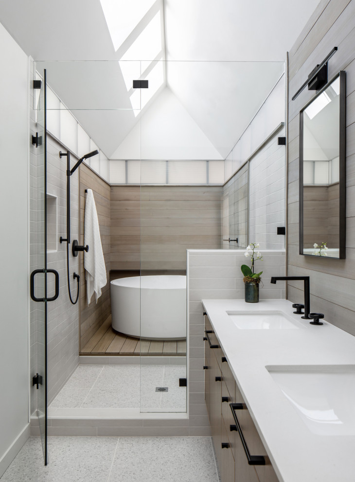 Свежая идея для дизайна: главная ванная комната среднего размера в современном стиле с плоскими фасадами, темными деревянными фасадами, душевой комнатой, раздельным унитазом, белой плиткой, керамической плиткой, серыми стенами, полом из керамогранита, врезной раковиной, столешницей из искусственного кварца, белым полом, душем с распашными дверями, белой столешницей, нишей, тумбой под две раковины, встроенной тумбой, сводчатым потолком и деревянными стенами - отличное фото интерьера