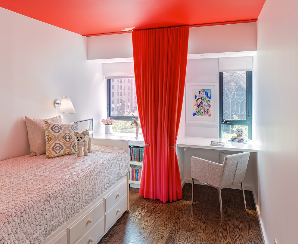Photo of a small contemporary gender-neutral kids' bedroom in New York with white walls and medium hardwood floors.