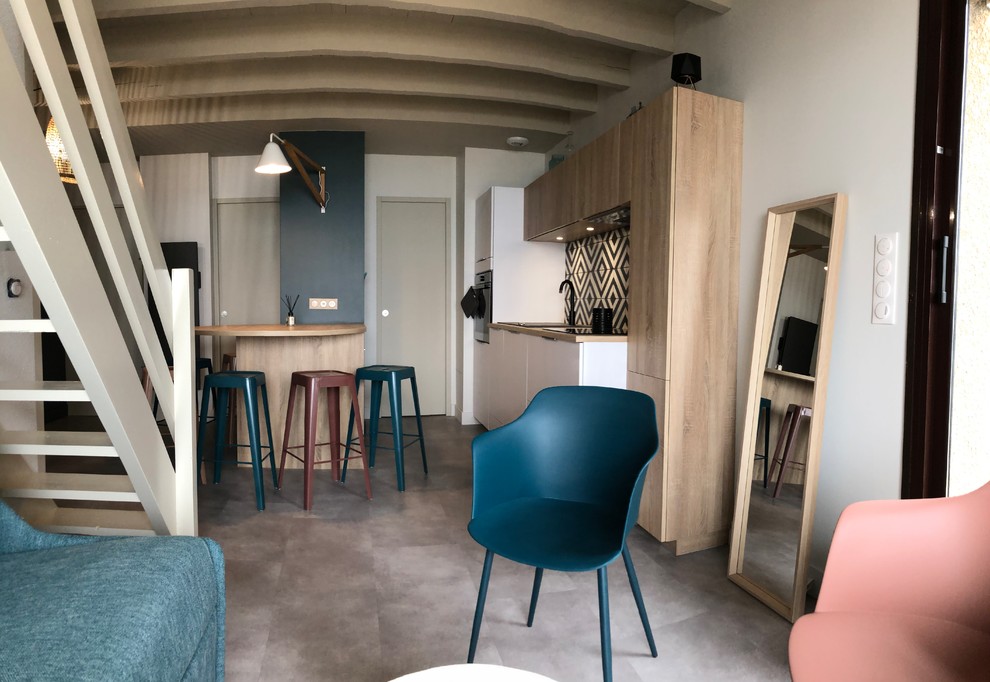 Aménagement d'une petite cuisine ouverte parallèle scandinave avec un évier encastré, un placard à porte affleurante, des portes de placard blanches, un plan de travail en stratifié, une crédence multicolore, une crédence en céramique, un électroménager noir, un sol en vinyl, une péninsule et un sol gris.