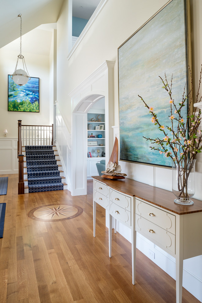 Foyer - large transitional light wood floor foyer idea with beige walls and a dark wood front door