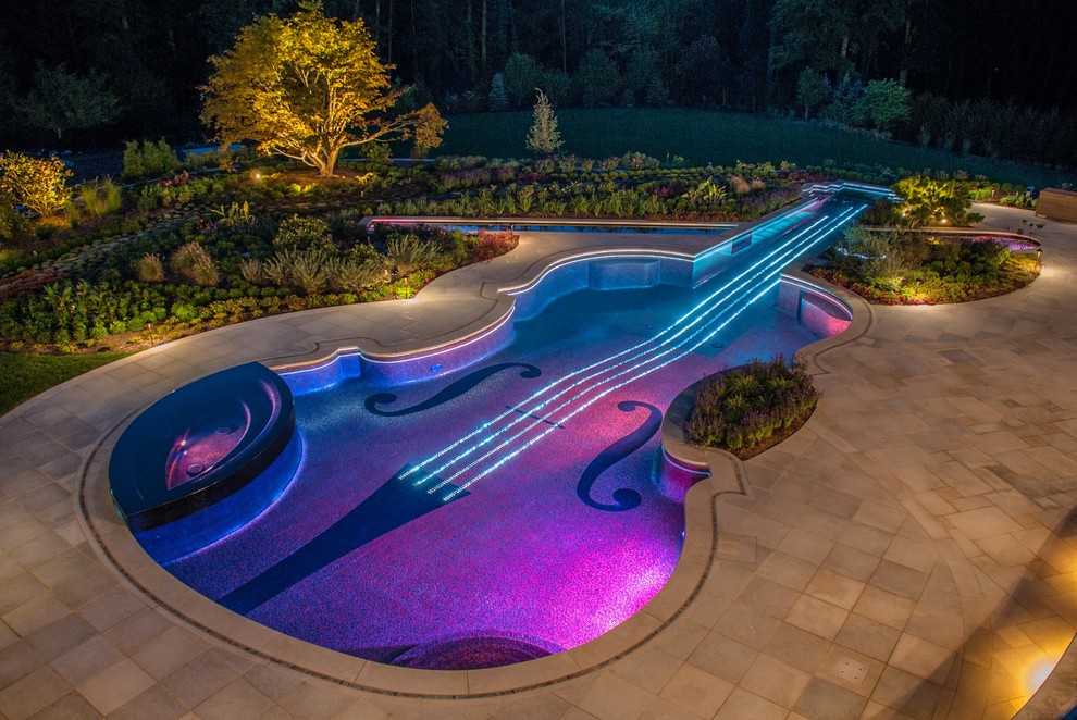 This is an example of an eclectic backyard custom-shaped pool in New York with a hot tub.