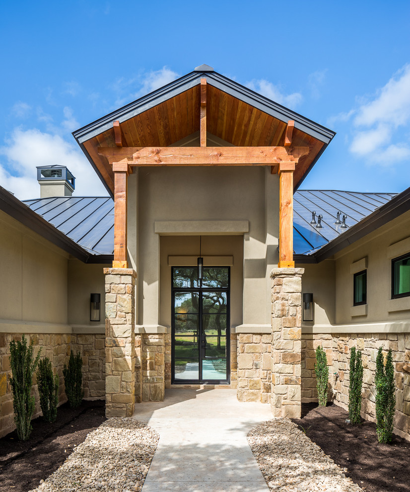 Example of a large transitional concrete floor front door design in Austin with beige walls and a glass front door