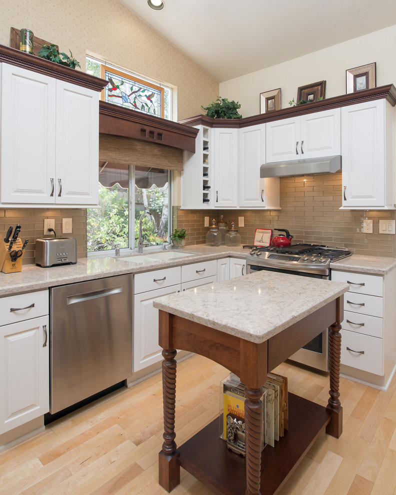 Mid-sized traditional u-shaped eat-in kitchen in San Diego with a double-bowl sink, raised-panel cabinets, white cabinets, granite benchtops, grey splashback, glass tile splashback, stainless steel appliances, light hardwood floors and with island.