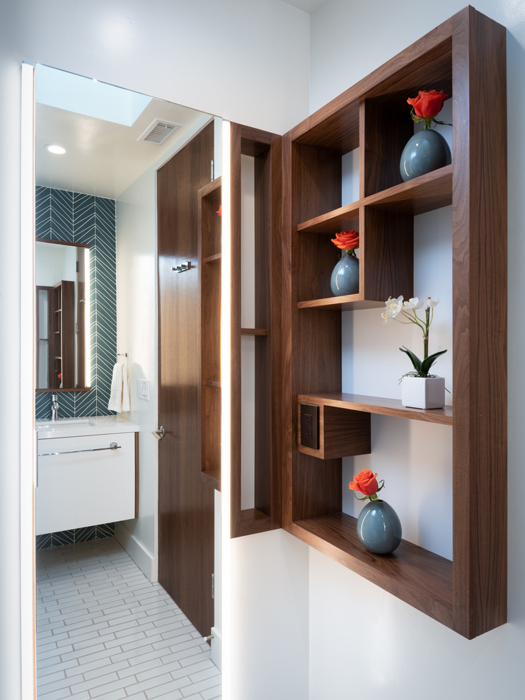 This is an example of a mid-sized midcentury kids bathroom in San Diego with flat-panel cabinets, white cabinets, a curbless shower, a one-piece toilet, white tile, glass tile, white walls, ceramic floors, an undermount sink, engineered quartz benchtops, a hinged shower door and white benchtops.