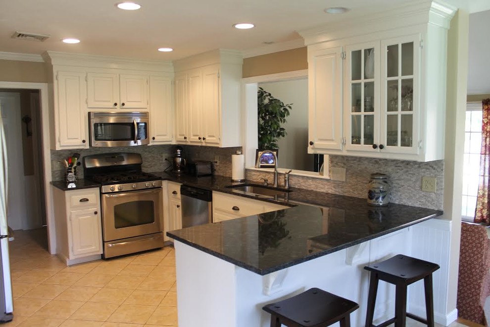 Inspiration for a mid-sized transitional u-shaped porcelain tile open concept kitchen remodel in Boston with an undermount sink, raised-panel cabinets, white cabinets, solid surface countertops, gray backsplash, mosaic tile backsplash, stainless steel appliances and a peninsula