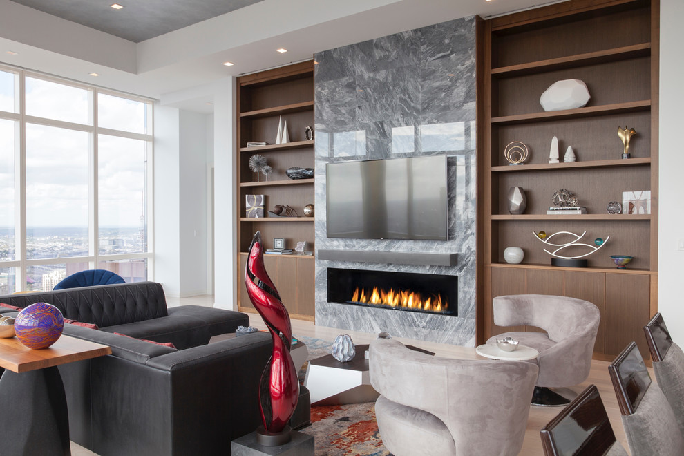 This is an example of a contemporary living room in Boston with white walls, light hardwood floors, a ribbon fireplace, a wall-mounted tv and beige floor.
