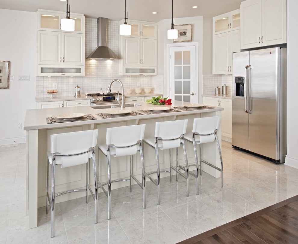 Inspiration for a transitional l-shaped porcelain tile and white floor kitchen remodel in Ottawa with an undermount sink, flat-panel cabinets, white cabinets, white backsplash, mosaic tile backsplash, stainless steel appliances and an island
