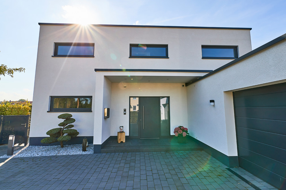 Geräumiges, Zweistöckiges Modernes Haus mit Putzfassade, weißer Fassadenfarbe und Flachdach in Sonstige