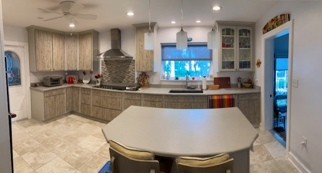 Large l-shaped eat-in kitchen photo with an undermount sink, flat-panel cabinets, medium tone wood cabinets, stainless steel appliances and an island