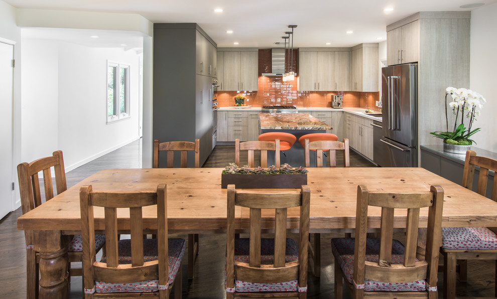 This is an example of an expansive contemporary u-shaped eat-in kitchen in Los Angeles with an undermount sink, flat-panel cabinets, grey cabinets, quartzite benchtops, orange splashback, glass tile splashback, stainless steel appliances, dark hardwood floors, with island and brown floor.