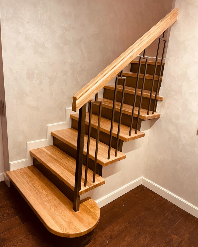 На фото: прямая лестница среднего размера в классическом стиле с деревянными ступенями, крашенными деревянными подступенками, металлическими перилами и обоями на стенах